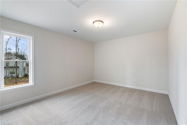 unfurnished room featuring light colored carpet, visible vents, and baseboards