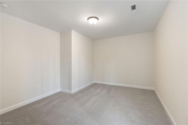 carpeted spare room with visible vents and baseboards