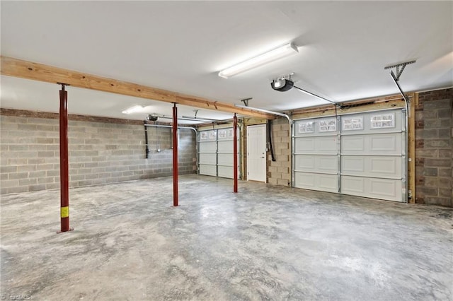 garage with concrete block wall and a garage door opener