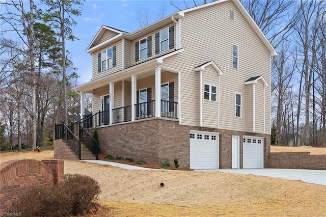 view of front of house with stairway, driveway, a porch, a garage, and brick siding