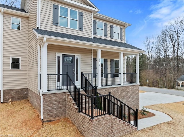 view of front of house with covered porch and a shingled roof