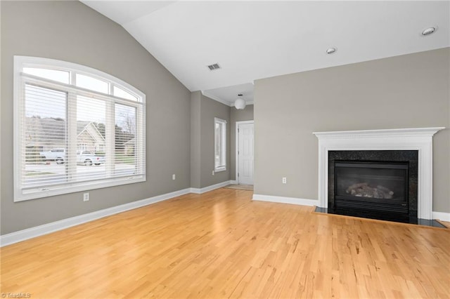 unfurnished living room featuring light hardwood / wood-style floors and vaulted ceiling