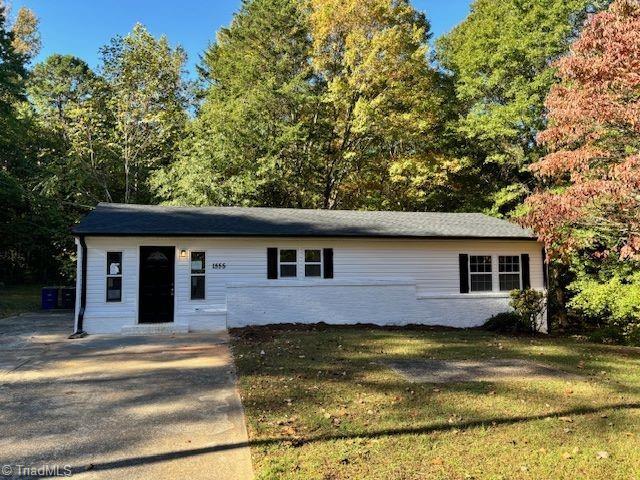 single story home featuring a front lawn