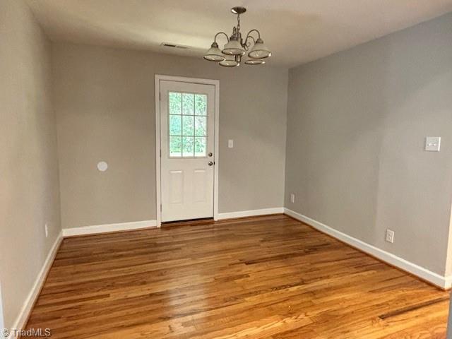 interior space featuring hardwood / wood-style floors and a notable chandelier