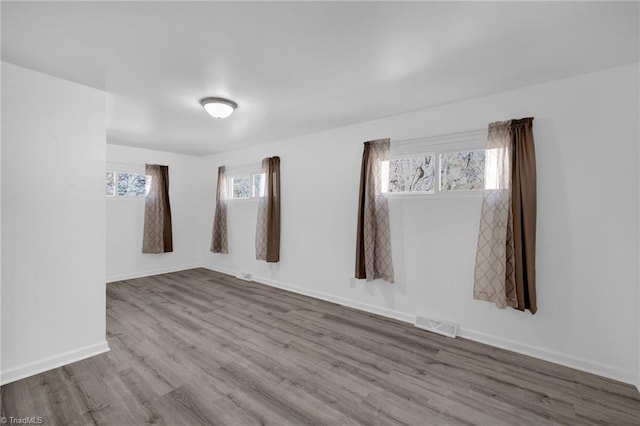 unfurnished room featuring hardwood / wood-style flooring and plenty of natural light