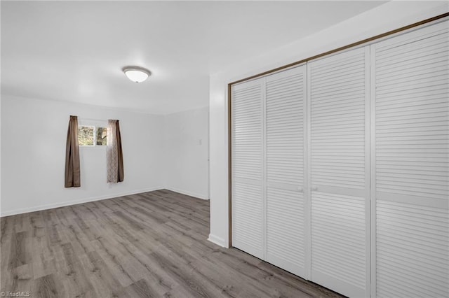 unfurnished bedroom featuring a closet and light wood-type flooring