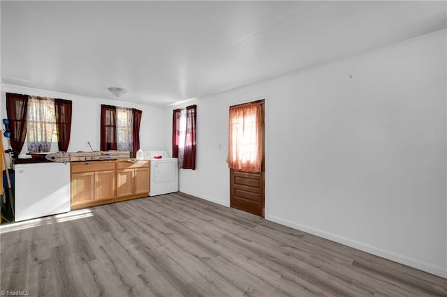 kitchen with white fridge, light brown cabinetry, washer / clothes dryer, and light hardwood / wood-style flooring