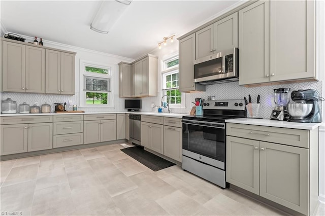 3401 Lochurst Ct, Pfafftown, NC 27040 - kitchen featuring appliances with stainless steel finishes, tasteful backsplash, gray cabinetry, and crown molding