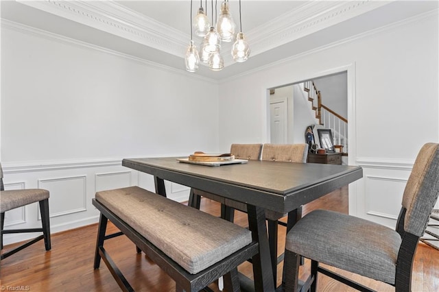 3401 Lochurst Ct, Pfafftown, NC 27040 - dining space with a decorative wall, wood finished floors, stairs, a chandelier, and a wainscoted wall