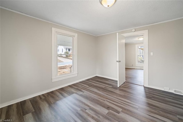 unfurnished room featuring a textured ceiling, dark wood-type flooring, and crown molding