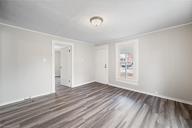 spare room featuring a textured ceiling, ornamental molding, and hardwood / wood-style flooring