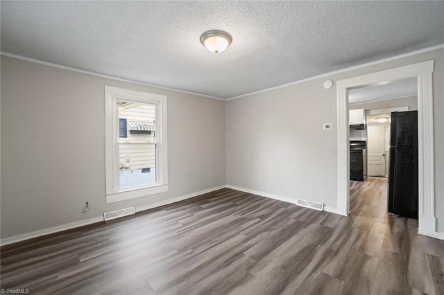 spare room featuring a textured ceiling, crown molding, and dark hardwood / wood-style flooring