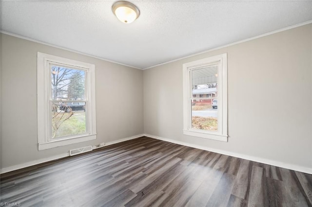 spare room featuring a textured ceiling, dark hardwood / wood-style floors, and ornamental molding