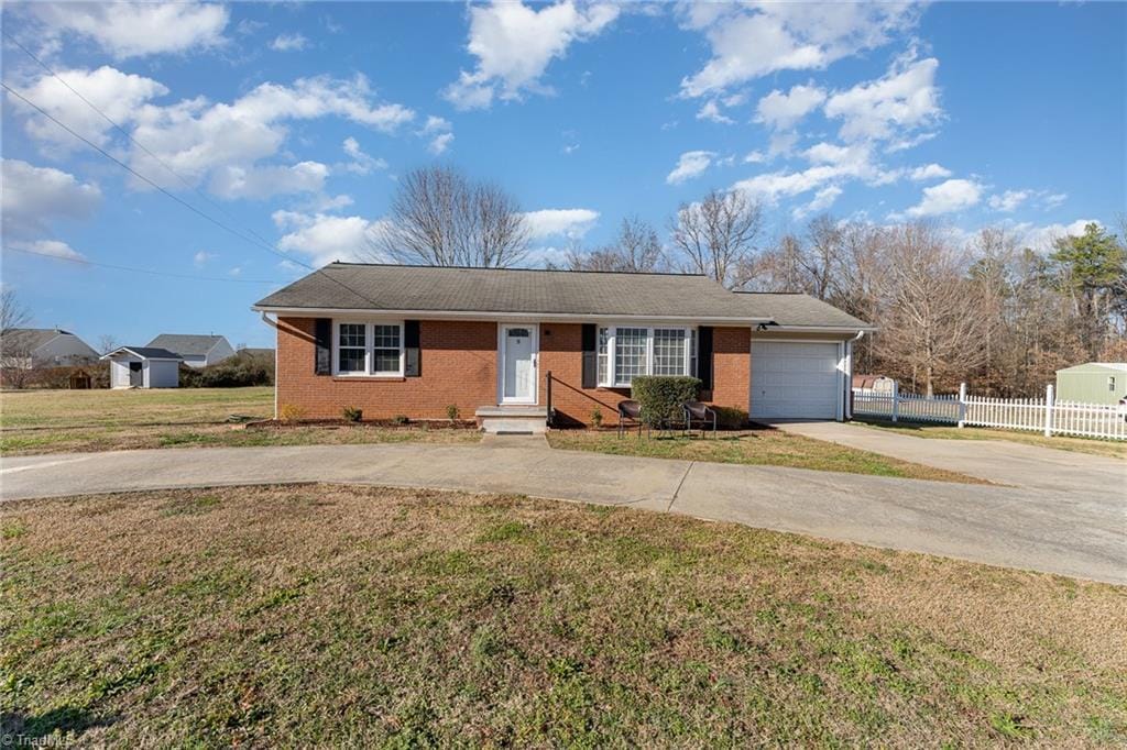 ranch-style home with a garage and a front yard