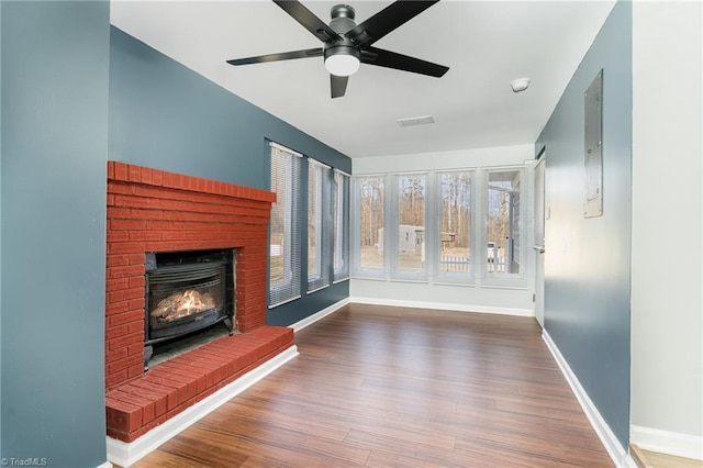 unfurnished living room featuring hardwood / wood-style flooring, ceiling fan, and a fireplace