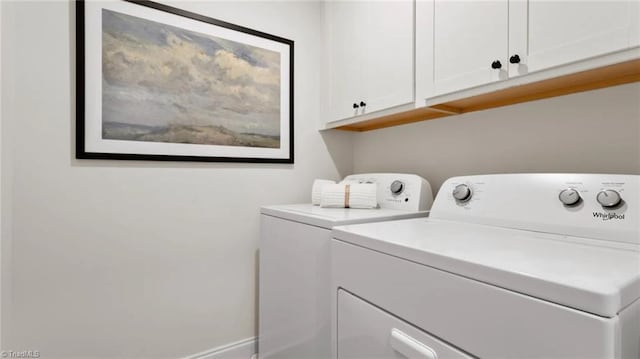 laundry area featuring washer and clothes dryer and cabinets