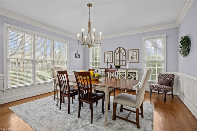 dining room with a wealth of natural light, ornamental molding, and an inviting chandelier