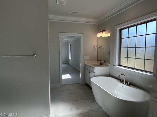 bathroom with a bath, vanity, and crown molding