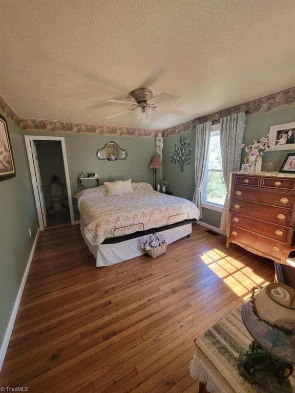 bedroom with dark wood-style floors, a textured ceiling, a ceiling fan, and baseboards