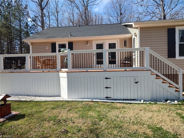 rear view of property with roof with shingles, stairway, a lawn, and a wooden deck