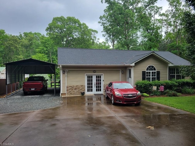 single story home featuring a carport, driveway, french doors, and a shingled roof