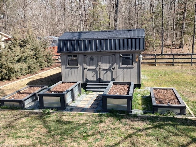 view of shed featuring a forest view, a garden, and fence