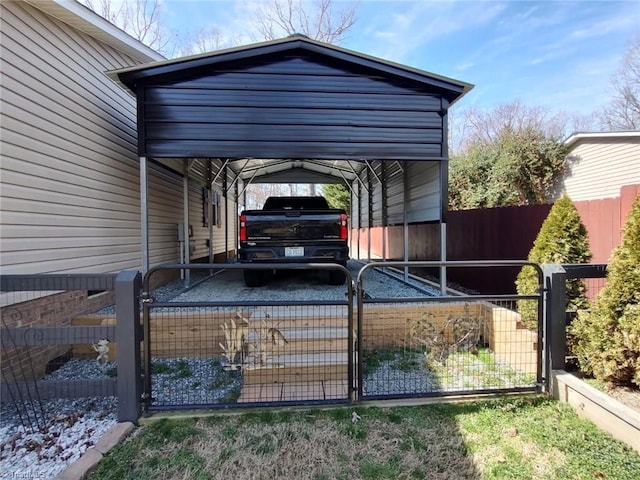 view of car parking featuring a gate, fence, and a carport