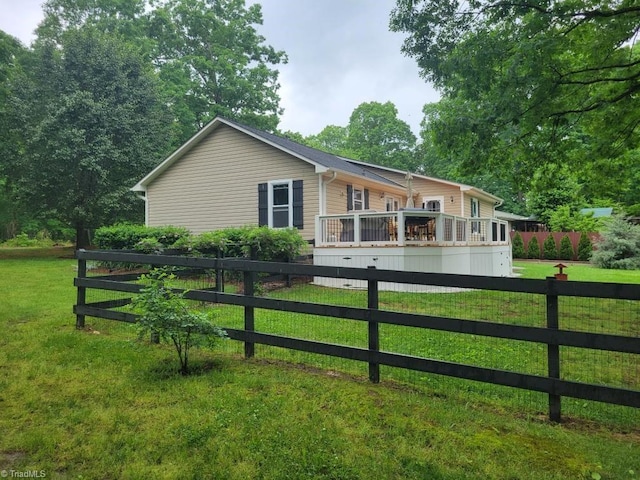 view of front of home featuring a deck, a front lawn, and fence