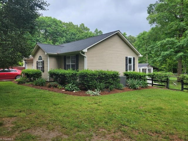 view of side of home featuring a lawn and fence