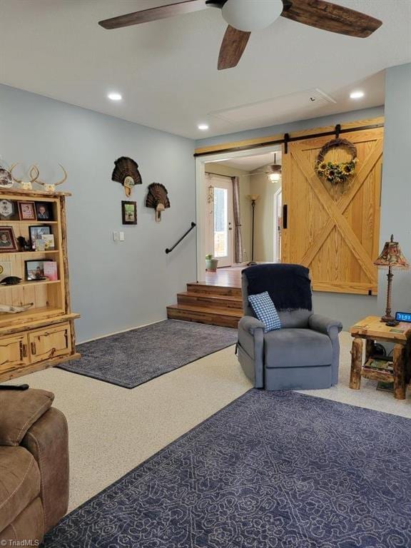 living area with a barn door, recessed lighting, carpet flooring, a ceiling fan, and stairway