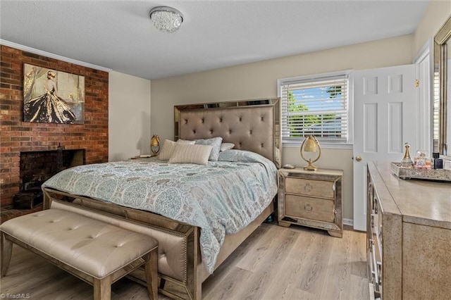 100 Monroe Dr, Lexington, NC 27295 - bedroom featuring a textured ceiling, baseboards, a fireplace, and light wood-style flooring