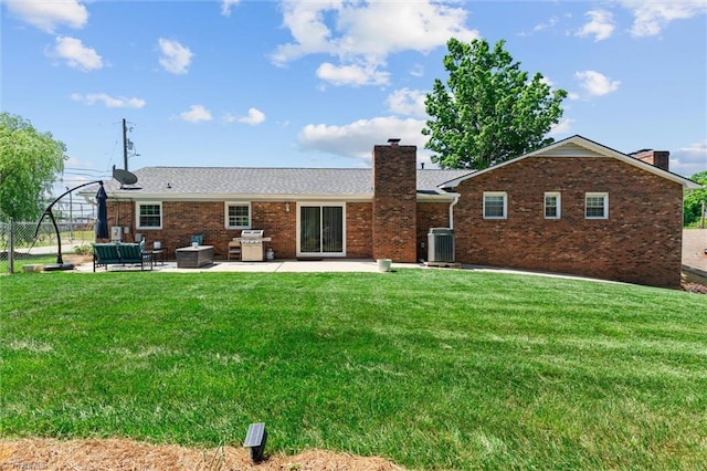 100 Monroe Dr, Lexington, NC 27295 - rear view of property featuring cooling unit, a patio, a chimney, brick siding, and a lawn