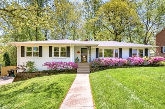 single story home featuring a chimney and a front lawn