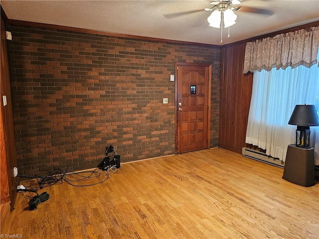 4875 Follansbee Rd, Winston-Salem, NC 27127 - foyer entrance with brick wall, ceiling fan, light wood finished floors, a textured ceiling, and ornamental molding