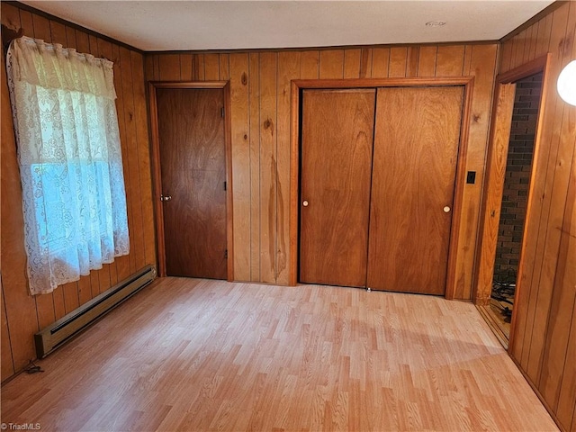 4875 Follansbee Rd, Winston-Salem, NC 27127 - unfurnished bedroom featuring a baseboard heating unit, wood finished floors, wood walls, and a closet