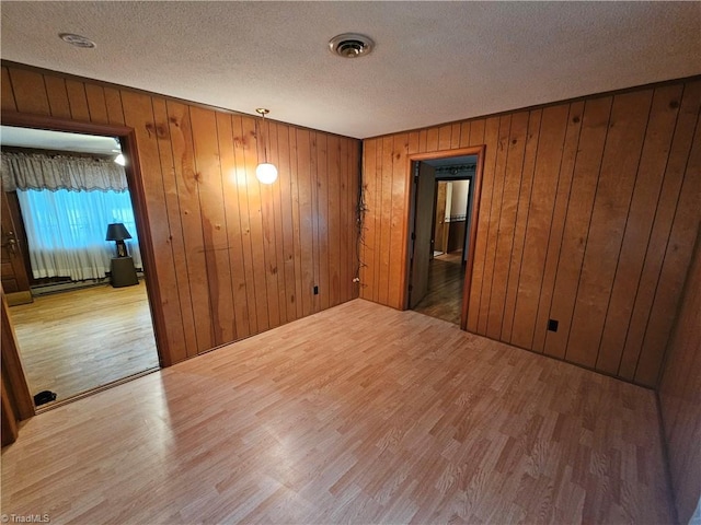 4875 Follansbee Rd, Winston-Salem, NC 27127 - empty room featuring wood finished floors, a textured ceiling, and wood walls