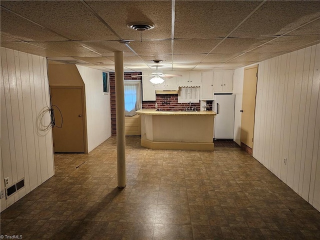 4875 Follansbee Rd, Winston-Salem, NC 27127 - kitchen featuring freestanding refrigerator, wood walls, under cabinet range hood, white cabinets, and a sink