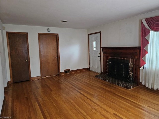 4875 Follansbee Rd, Winston-Salem, NC 27127 - unfurnished living room featuring wood finished floors, a brick fireplace, and baseboards