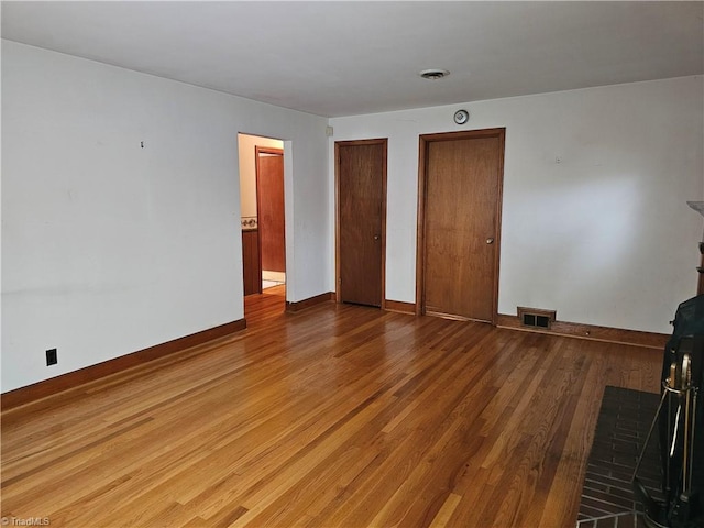 4875 Follansbee Rd, Winston-Salem, NC 27127 - unfurnished bedroom featuring baseboards, wood finished floors, and two closets