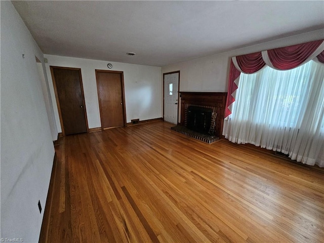 4875 Follansbee Rd, Winston-Salem, NC 27127 - unfurnished living room featuring wood finished floors, a fireplace, and baseboards