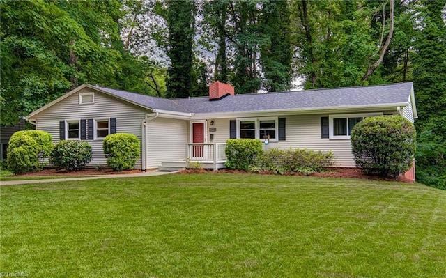 ranch-style home with a chimney and a front lawn