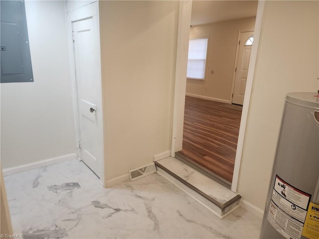 laundry room with electric water heater, visible vents, baseboards, marble finish floor, and electric panel