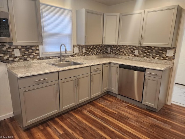 kitchen with appliances with stainless steel finishes, a sink, and gray cabinetry