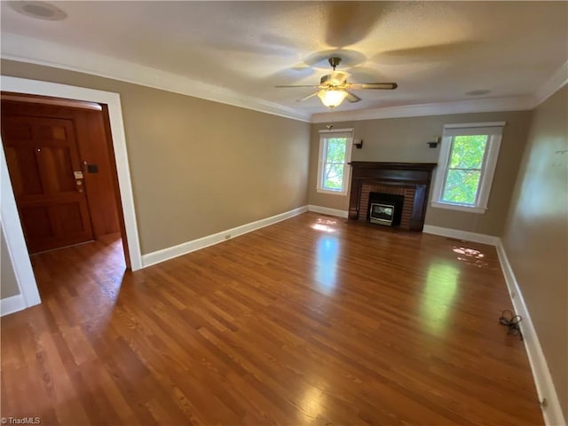 unfurnished living room featuring a brick fireplace, ceiling fan, plenty of natural light, and hardwood / wood-style floors