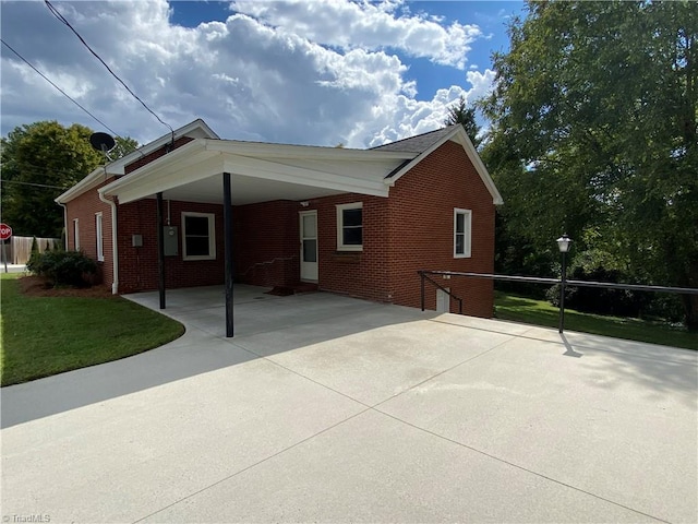 view of home's exterior with a lawn and a carport