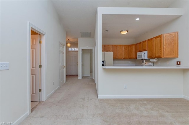 kitchen featuring visible vents, white appliances, light carpet, and light countertops