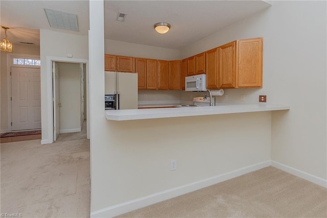 kitchen featuring white appliances, light countertops, visible vents, and light carpet