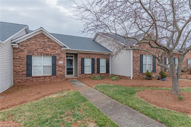 ranch-style home with brick siding and a shingled roof