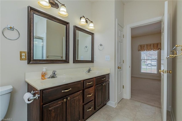 full bathroom with double vanity, tile patterned floors, toilet, and a sink