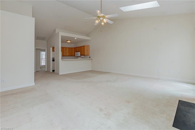 unfurnished living room with baseboards, light carpet, a skylight, high vaulted ceiling, and a ceiling fan